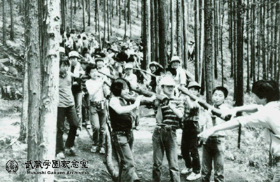 学校山林の間伐 学校山林から間伐材を運び出す生徒たち 間伐材は鵜原寮の改築（1988年）に用いられた。